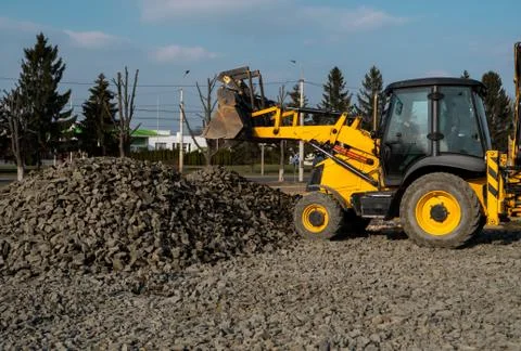 Yellow wheel loader Excavator machine working at construction site with gravel Stock Photos