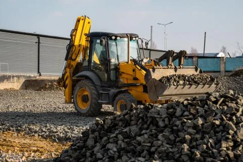 Yellow wheel loader Excavator machine working at construction site with gravel Stock Photos