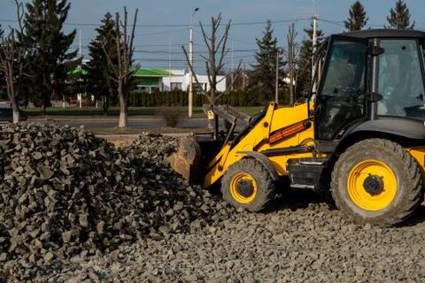 Yellow wheel loader Excavator machine working at construction site with gravel Stock Photos