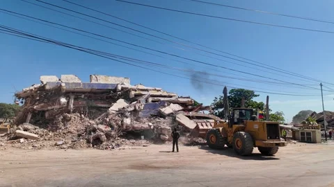 Yellow wheel loader removing debris from collapsed building after 2026 Stock Footage 341745706