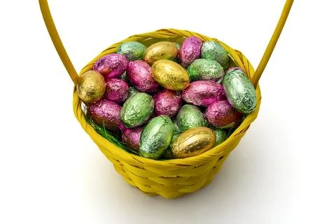 Yellow Wicker Easter Basket with Foil Wrapped Chocolate Eggs Isolated Stock Photos