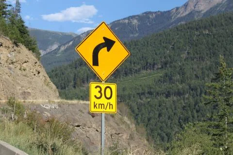 Yellow Winding Road Sign - Slow Down Stock Photos