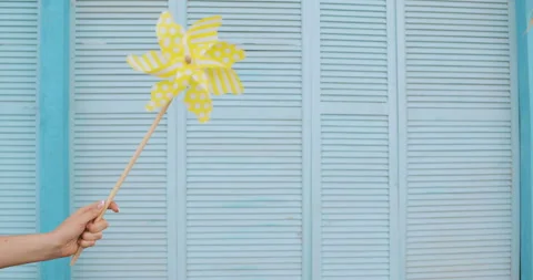 Yellow windmill spinning in wind on blue deck background. summer concept Stock Footage 93389972