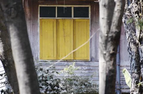 Yellow window white frame of old wooden house Stock Photos