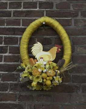Yellow wreath for easter on a wall with easter eggs and flowers Stock Photos