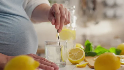 Yellow, young parent preparing refreshing lemonade with mint in housewife's Stock Footage 247664026