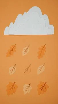 Yellowed leaves fall from the cloud instead of raindrops Stock Photos