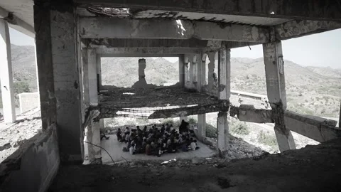 Yemeni children study inside a school destroyed by the war in Taiz City Stock Footage 160281499