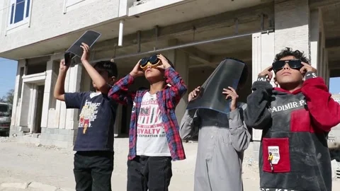 Yemenis watch partial solar eclipse from Sana'a, Saná (es-ES), YE - 26 Oct 2022 Stock Footage 219907177