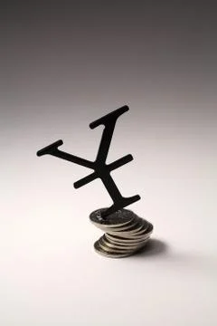 Yen symbol on a stack of coins Stock Photos