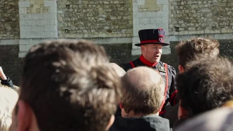 Yeomen Warder talking in front of tourists during a tour of the Tower of Stock Footage 213880474