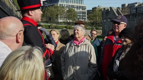 Yeomen Warder tour guide talking in front of tourist group during a tour Stock Footage 213916500