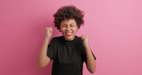 Yes I did it. Overjoyed Afro American woman clenches fists feels lucky and glad Stock Footage 150296898