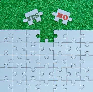 Yes or no decision concept with puzzle pieces on green background Stock Photos
