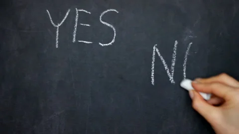 Yes or No decision making - choosing YES on chalkboard. Woman hand writes on a Stock Footage 122741760