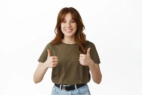 Yes very good. Smiling young woman showing thumbs up, approve and like Stock-Fotos