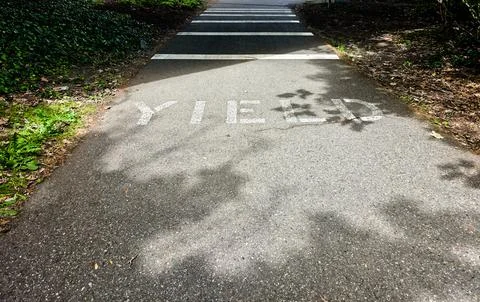 Yield Marking on Paved Trail Approaching Pedestrian Crosswalk Stock Photos