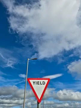 Yield road sign against dramatic cloudy sky Stock Photos