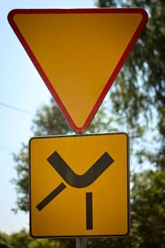 Yield sign with side road junction symbol on a sunny rural roadside 스톡 사진
