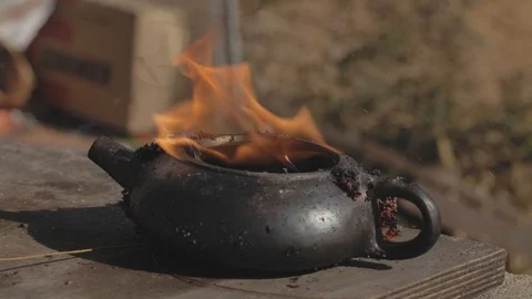 Yixing clay pot for tea in the flame after roasting in a fire. Handmade Stock Footage 119336307