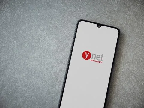 Ynet app launch screen with logo on the display of a black mobile smartphone  Stock Photos