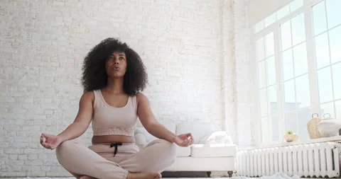 Yoga and breathing techniques practiced by a young, cheerful mixed-race woman Stock-Footage 159168527