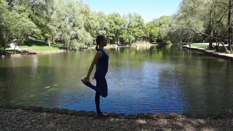 Yoga balancing at the pond Stock Footage 90381262