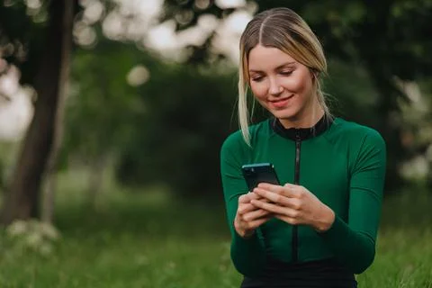 Yoga classes on the grass in the park using a mobile phone. Stock Photos