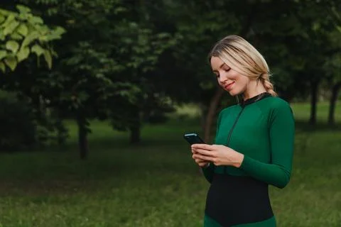 Yoga classes on the grass in the park using a mobile phone. Stock Photos