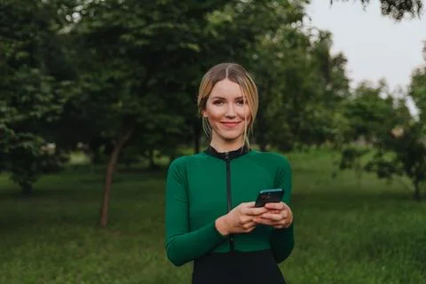 Yoga classes on the grass in the park using a mobile phone. Stock Photos