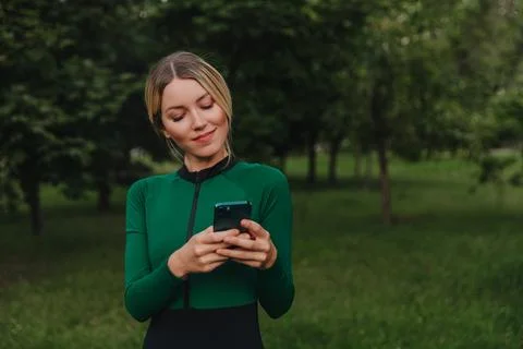 Yoga classes on the grass in the park using a mobile phone. Stock Photos
