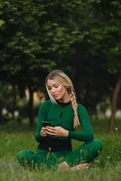 Yoga classes on the grass in the park using a mobile phone. Foto stock