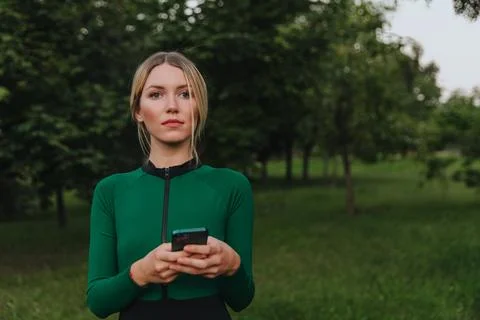 Yoga classes on the grass in the park using a mobile phone. Stock Photos