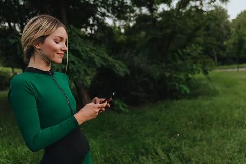 Yoga classes on the grass in the park using a mobile phone. Stock Photos