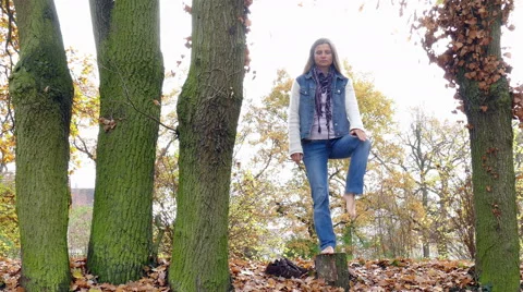 Yoga exercise on a tree stump in autumn Stockbeeldmateriaal 56736631