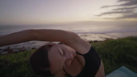 Yoga exercises with ocean view on sunset. Caucasian fit woman doing yoga Stock Footage 244829619