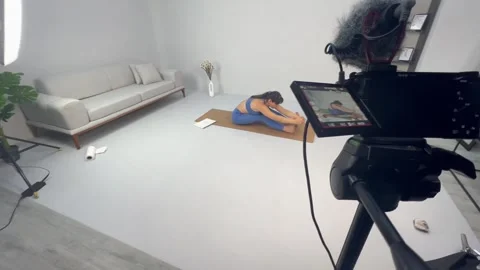 A yoga girl make exercise in studio. modern video setup with camera and lighting Stock Footage 293058731