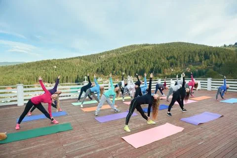 Yoga group practicing revolved triangle. Stock Photos