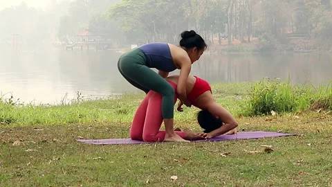 Yoga instructor assists adjusts student in Yoga Practice. Stock Footage 137409330