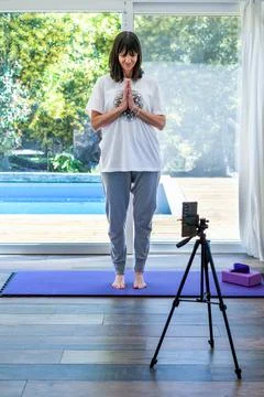 Yoga instructor creating content for her social media platforms in her home Stock Photos