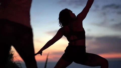 Yoga instructor forms pose against setting sun 스톡 동영상 138592629