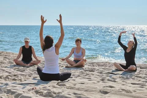 Yoga instructor leading group practice on Sandy Baltic Sea Beach in morning.. Stock Photos