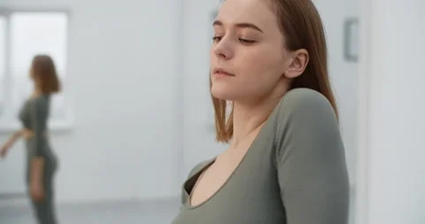 Yoga instructor performs warm up exercises for shoulders at the white hall Stock Footage 147380447