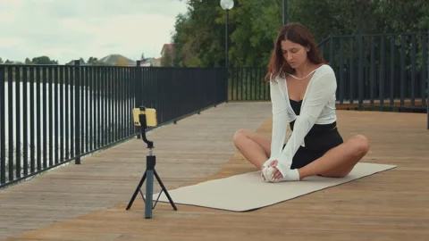 Yoga instructor streaming online class outdoors Stock Footage 315524793