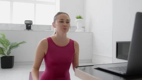 Yoga instructor teaching online class in modern living room Stock Footage 248308373