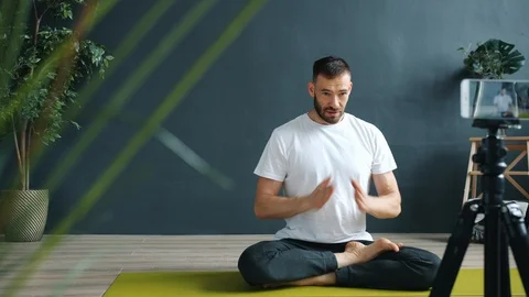 Yoga instructor teaching online recording tutorial in studio with smartphone 库存影片 121822643