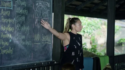 Yoga instructor teaching yoga on blackboard Stock Footage 75289875
