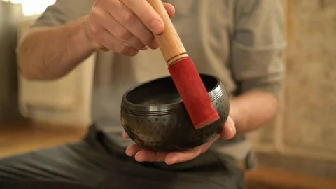 Yoga instructor using Tibetan singing bowl in yoga class Stock Footage 112999504