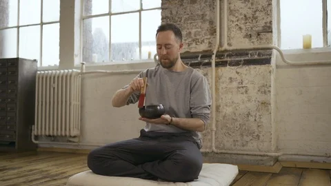 Yoga instructor using Tibetan singing bowl in yoga class Stock Footage 113002647