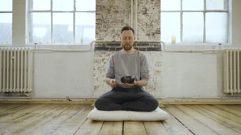 Yoga instructor using Tibetan singing bowl in yoga class Stock Footage 113002759